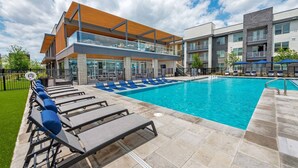 A modern pool area with lounge chairs and a clear blue pool. - Sleeps 10 w/King Bed+Gym+Free Parking+Stockyards (Fort Worth)