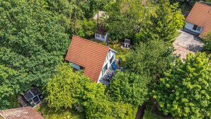 Luchtbeeld van een woonwijk met huizen te midden van weelderige begroeiing.