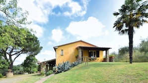 A yellow house with a stone foundation, a patio with chairs, and a palm tree. - Stunning home in Lucignano (Lucignano)