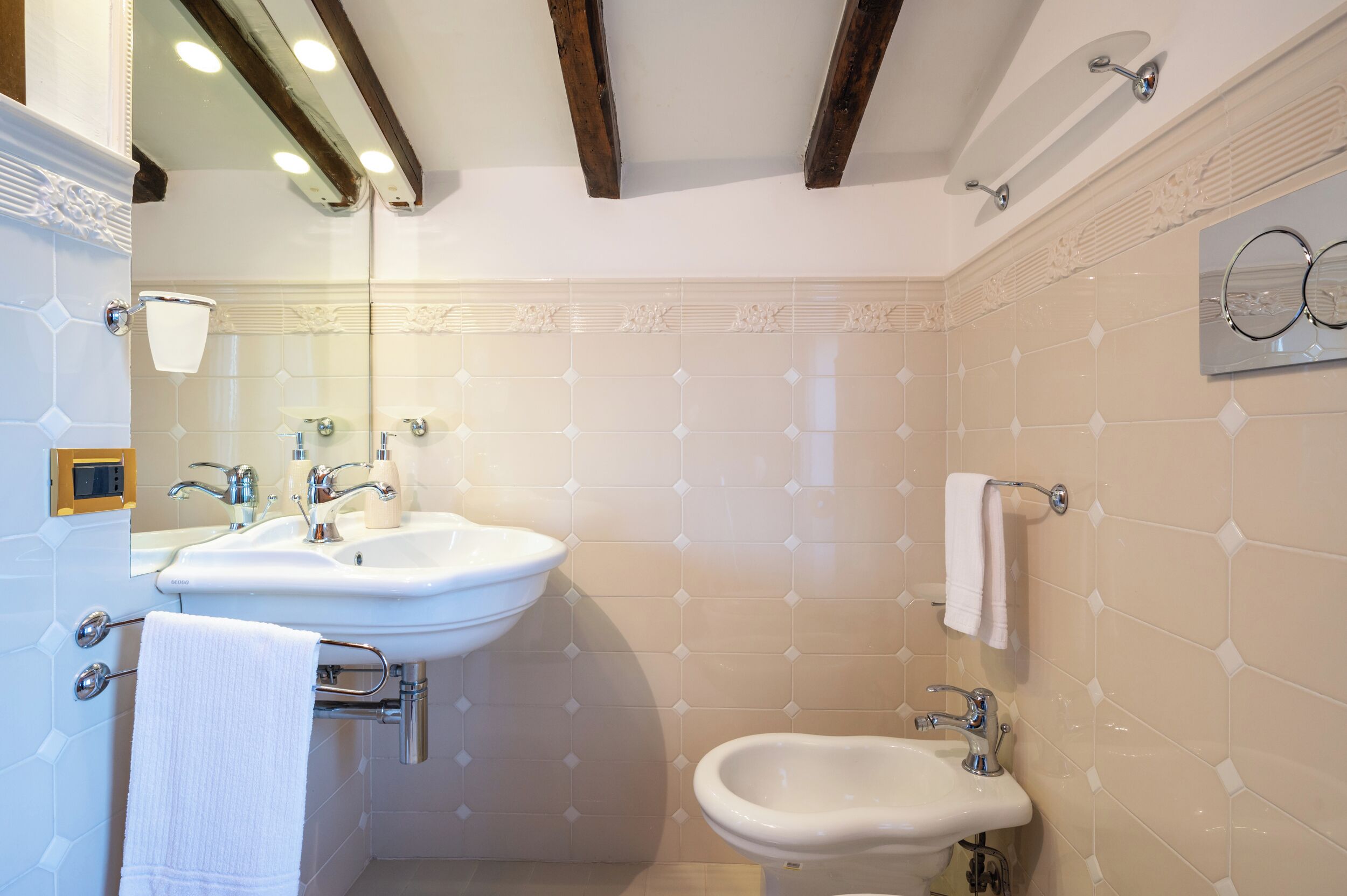 A bathroom with two sinks, a bidet, and a towel rack.
