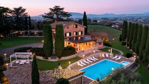 A large house with a swimming pool, outdoor seating, and a view of the surrounding landscape. - Tenuta Cavi 10, Emma Villas (Recchia)