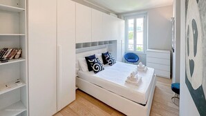 Une chambre moderne avec un lit, une armoire intégrée et une fenêtre.