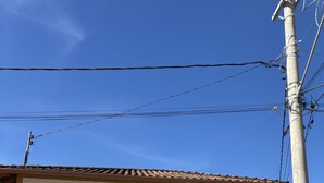 A building with three windows, a stone base, and a tiled roof. - Pousada Casa Matriz (Itabirito)