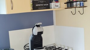 Una cocina compacta con estufa a gas, microondas y una pequeña encimera.