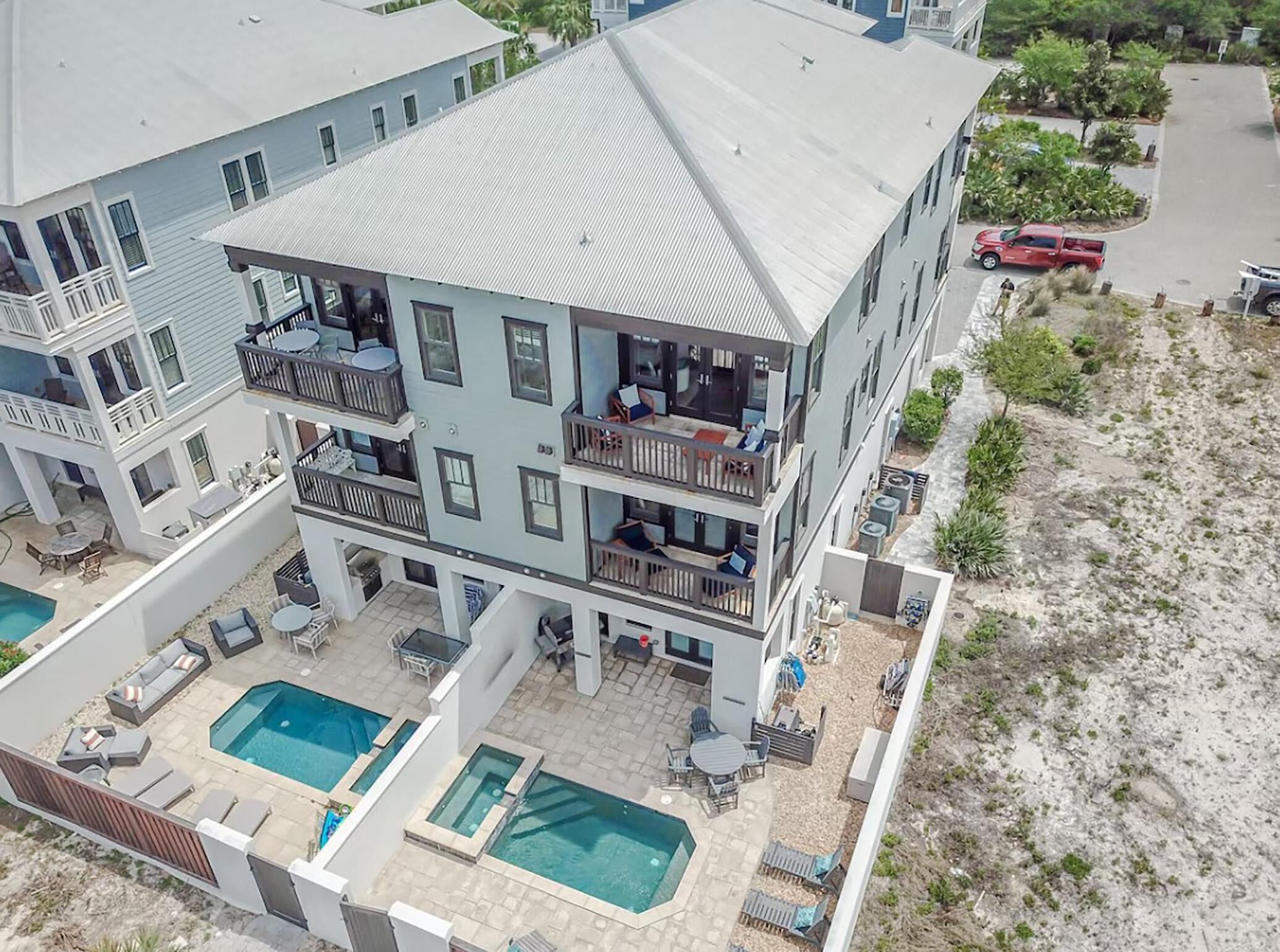 A multi-story building with a rooftop pool, outdoor seating, and a covered patio area.