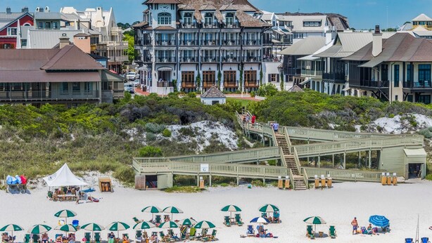 A beachfront hotel with a prominent tower, a boardwalk leading to the beach, and beach umbrellas. - Inlet Beach Retreat 202 (Panama City Beach)