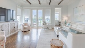 A spacious living room with a wooden ceiling, white furniture, and large windows. - Inlet Beach Retreat 202 (Panama City Beach)