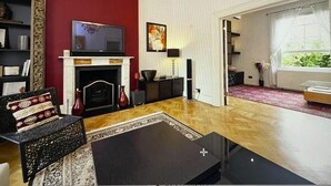 Ein Wohnzimmer mit Kamin, Fernseher und einer roten Akzentwand.