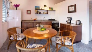 Una cocina compacta con una mesa, sillas y un refrigerador.