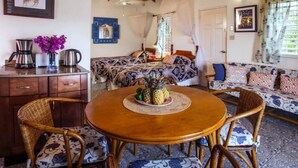 Una habitación acogedora con cama, sofá, mesa de comedor con sillas y una zona de café.