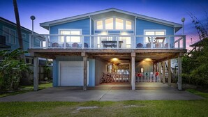 A two-story house with a covered front porch, a garage, and a balcony. - The Bent Rod-Charming Canal home! (Jamaica Beach)