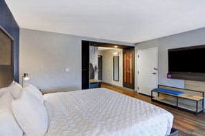 A modern hotel room with a large bed, a bench, a TV, and a mirror. - Tru By Hilton Augusta Washington Road (Augusta)