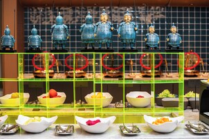 Un bufé con diversos alimentos y estatuas decorativas.