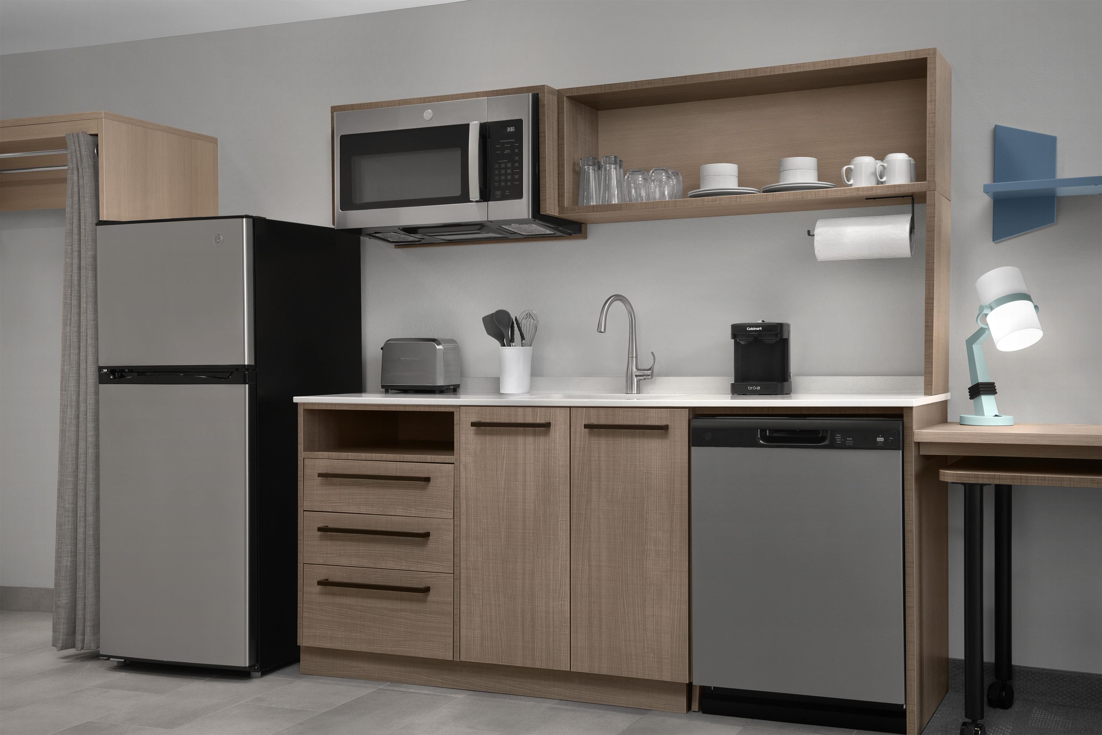 A modern kitchen with a built-in microwave, a coffee machine, and a dishwasher.