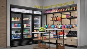 A snack display with refrigerated and shelf sections, including various snacks and beverages. - Home2 Suites By Hilton Ashburn, Va (Ashburn)