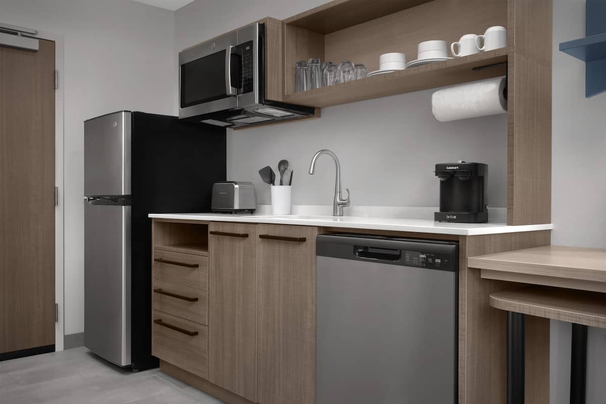 Una cocina moderna equipada con microondas, cafetera y lavavajillas.