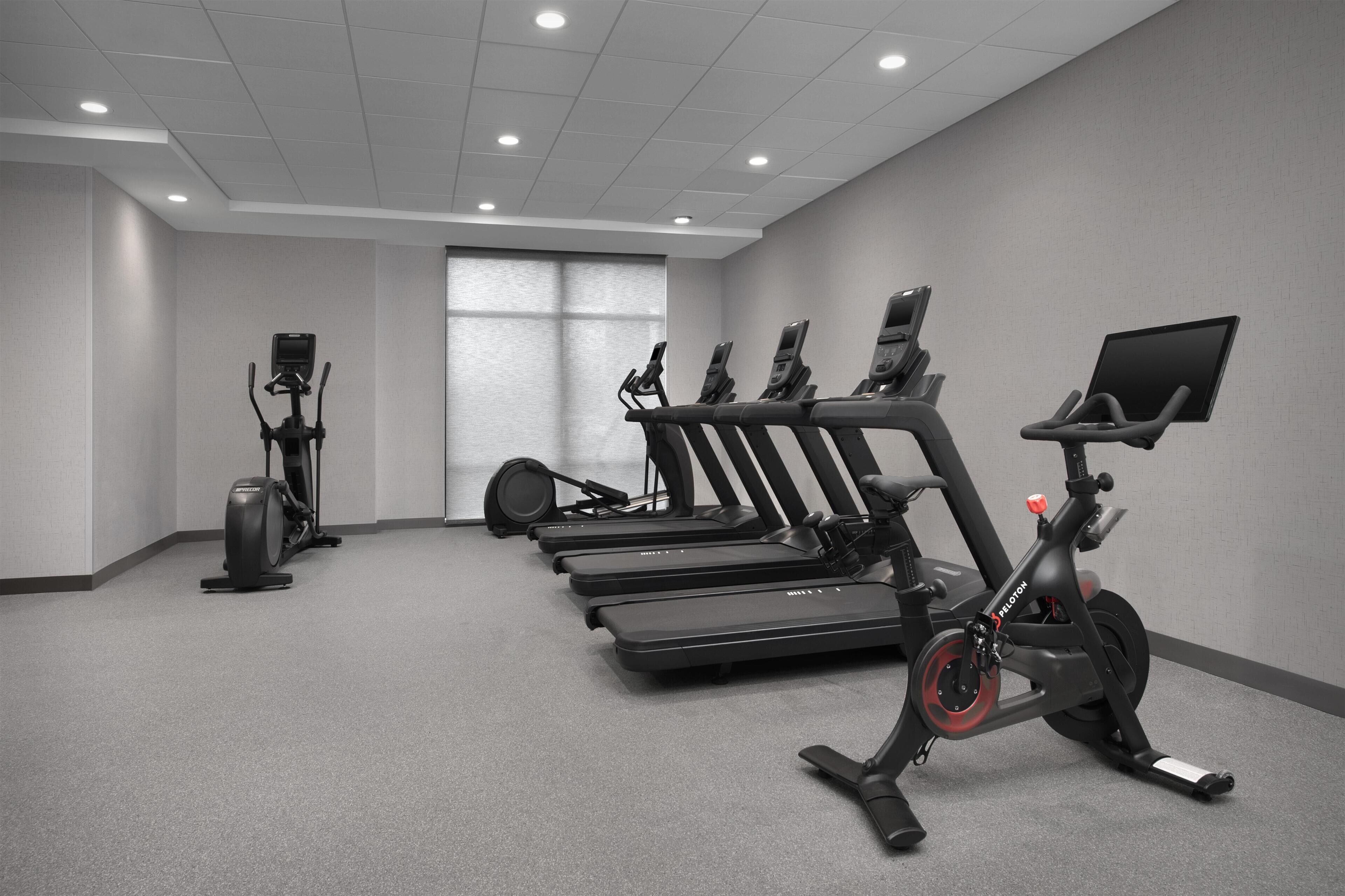 A gym with treadmills, an elliptical, and a stationary bike.