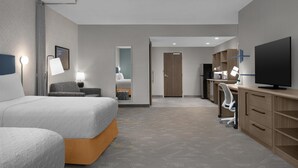 A hotel room with a bed, a desk, a TV, and a chair. - Home2 Suites By Hilton Ashburn, Va (Ashburn)