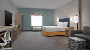 Une chambre d’hôtel équipée d’un lit, d’un bureau, d’une chaise et d’un téléviseur.