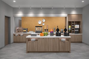 A modern kitchen area with a central island, a coffee machine, and a waffle station. - Home2 Suites By Hilton Ashburn, Va (Ashburn)