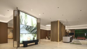 A modern lobby with a reception desk, a large digital display, and a seating area. - Hilton Garden Inn Zhongwei Shapotou (Zhongwei)