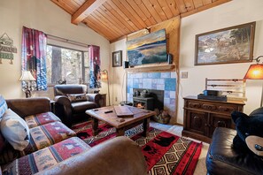 A cozy living room with a fireplace, leather furniture, and patterned rugs. - A Beary Cute Cabin (Sugarloaf)