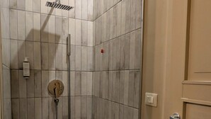 A small, tiled shower area with a handheld showerhead and a handheld faucet. - Palazzo Russo Ortigia Suite & Apartments (Syracuse)