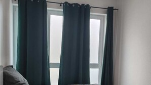 A bedroom with a bed, dark curtains, and a window. - Exclusive City Apartment Perfect Business Stays (Tuttlingen)