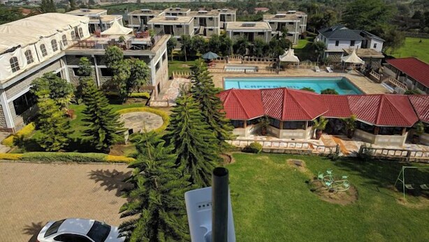 Um grande resort com vários edifícios, piscina e vista para a paisagem ao redor.