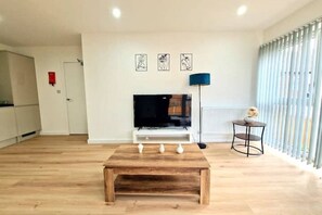 Relax in this stylish living room with a flat-screen TV, artworks, and a comfortable seating area.