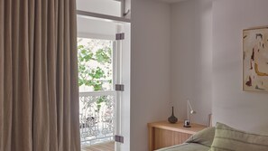 A room with a bed, a bedside table with a lamp, and a window with curtains. - Riley House, Surry Hills Isyd (Surry Hills)