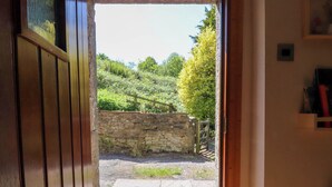 A stone wall and wooden gate leading to a paved area. - Sunnybrook Cottage (Lancaster)