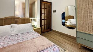 A bedroom with a wooden bed, a nightstand, a mirror, and a rattan wardrobe. - Elegant holiday home situated in Salerno, city centre, a few km from Amalficoast (Salerno)