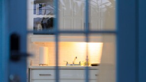 Une cuisine avec des meubles blancs, un plan de travail et un évier.