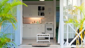 Une cuisine moderne avec des meubles blancs, une petite table et un ventilateur de plafond.