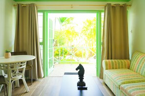 A room with a balcony, a sofa, a table, and a decorative horse statue.