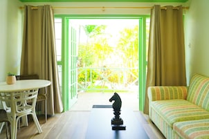 Una habitación con balcón, un sofá, una mesa y una estatua decorativa de un caballo.