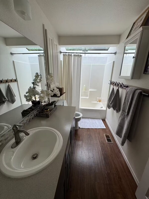 Un bagno moderno con uno specchio grande, un lavabo e una zona doccia.