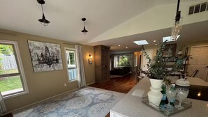 A spacious kitchen with a large island, wooden flooring, and a patterned rug. - Careys Refuge - Family Retreat with Huge Fenced Yard (Bothell)