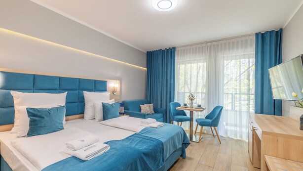 Ein modernes Hotelzimmer mit einem großen Bett, einem Schreibtisch und einem Stuhl.