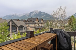 A residential area with a wooden deck overlooking a mountain range.