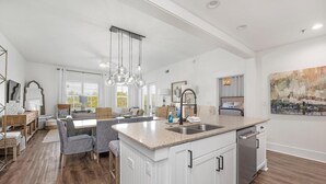 A spacious kitchen with a central island, white cabinetry, and pendant lighting. - Redfish Village M2321- Changes in Latitude (Santa Rosa Beach)