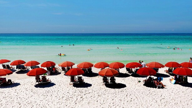 A beach with red umbrellas and white sand. - Redfish Village M2321- Changes in Latitude (Santa Rosa Beach)