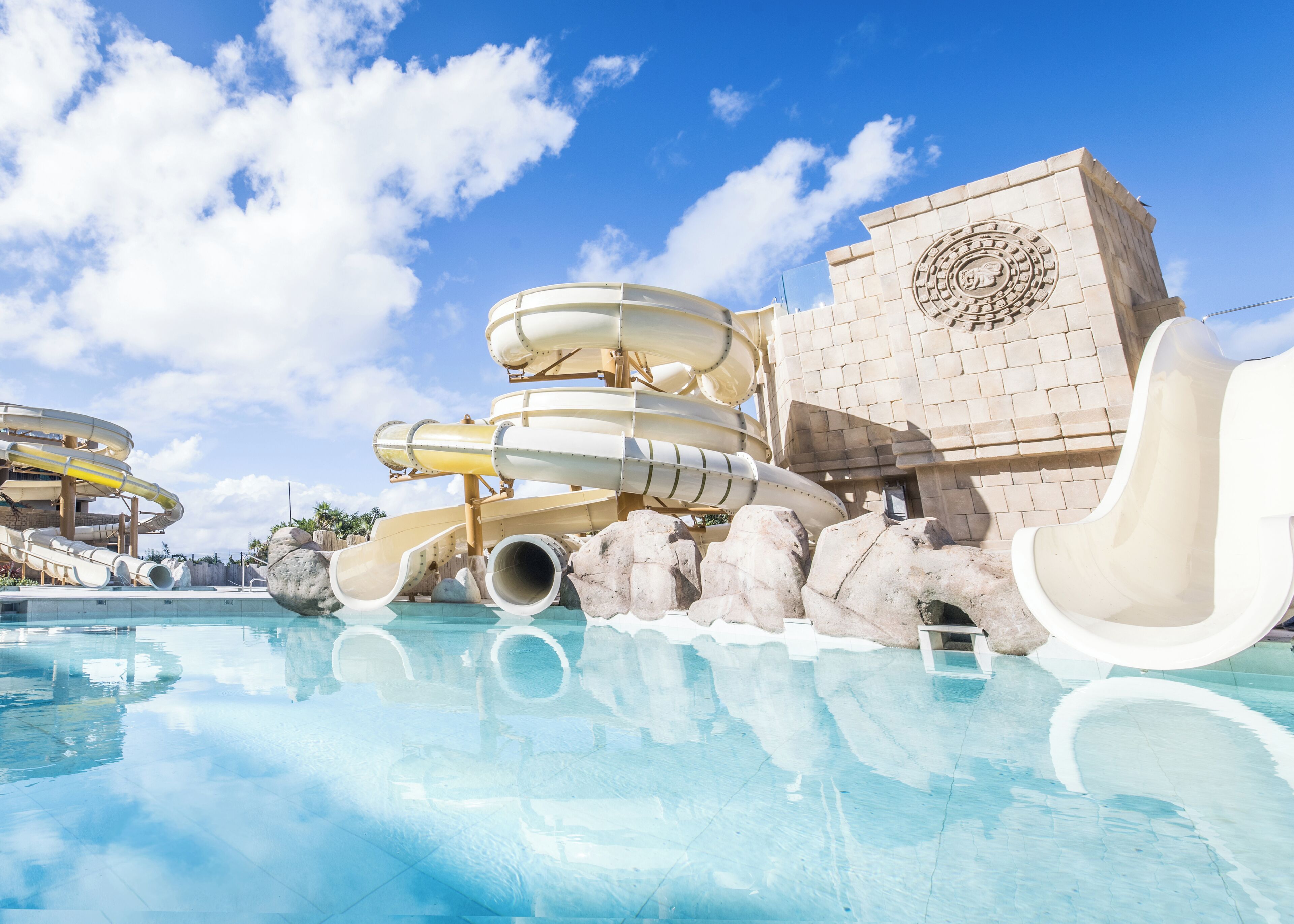 A water park with multiple slides and a pool.