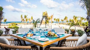 Una mesa lista para comer con vista a la playa y al océano.