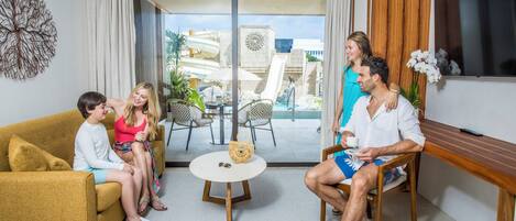 A modern living room with a sofa, a round table, and a view of an outdoor pool area.