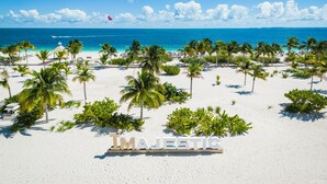 Una playa con palmeras y un cartel que dice 'MAJESTIC'.