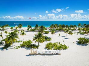Una playa con palmeras y un cartel que dice 'MAJESTIC'.