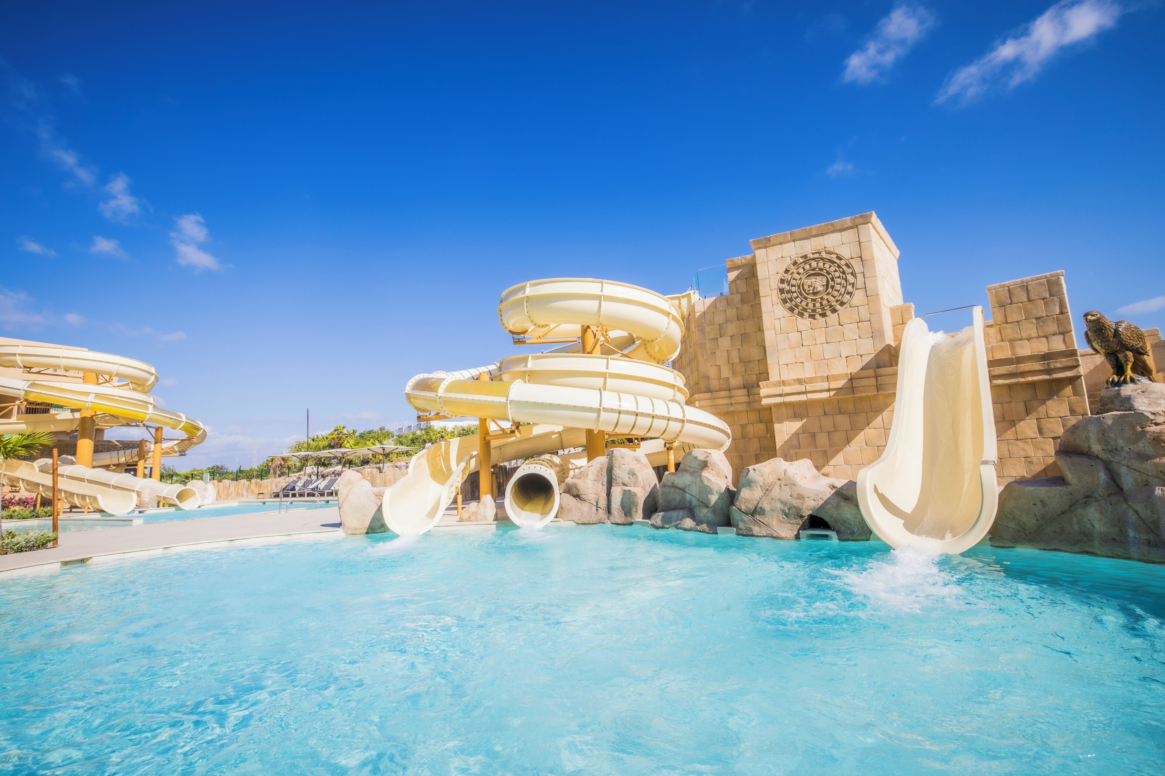 Un parque acuático con múltiples toboganes y una piscina.