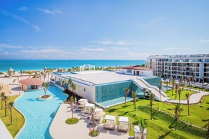 Un resort con piscina, palmeras y vista al océano.